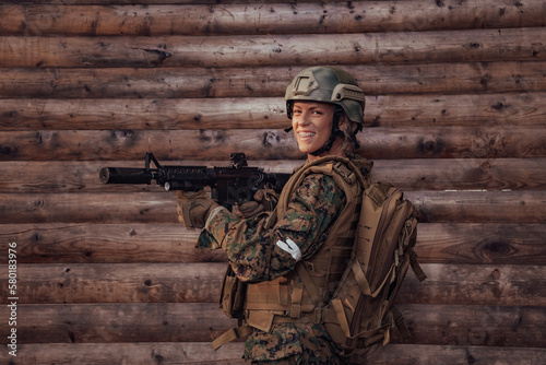 Woman soldier ready for battle wearing protective military gear and weapon