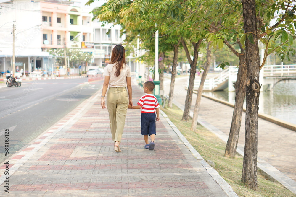 Mother takes baby for a walk in the park holiday Mother takes baby for a walk in the park holiday