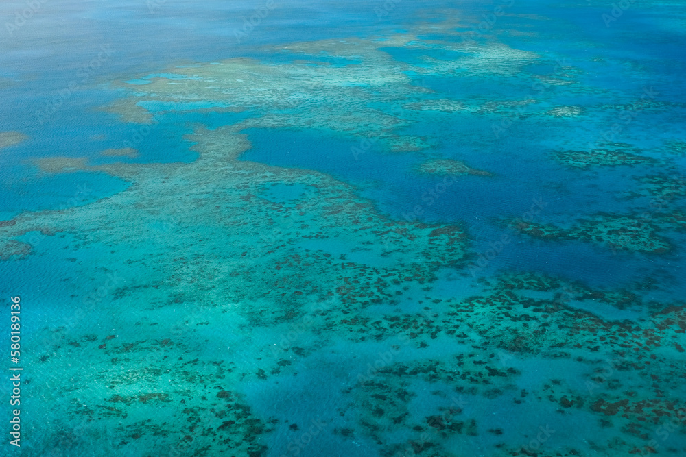 Obraz premium An aerial view of the coral reefs, white sand bars, tropical isles and clear turquoise waters of the Great Barrier Reef — Coral Sea, Cairns; Far North Queensland, Australia
