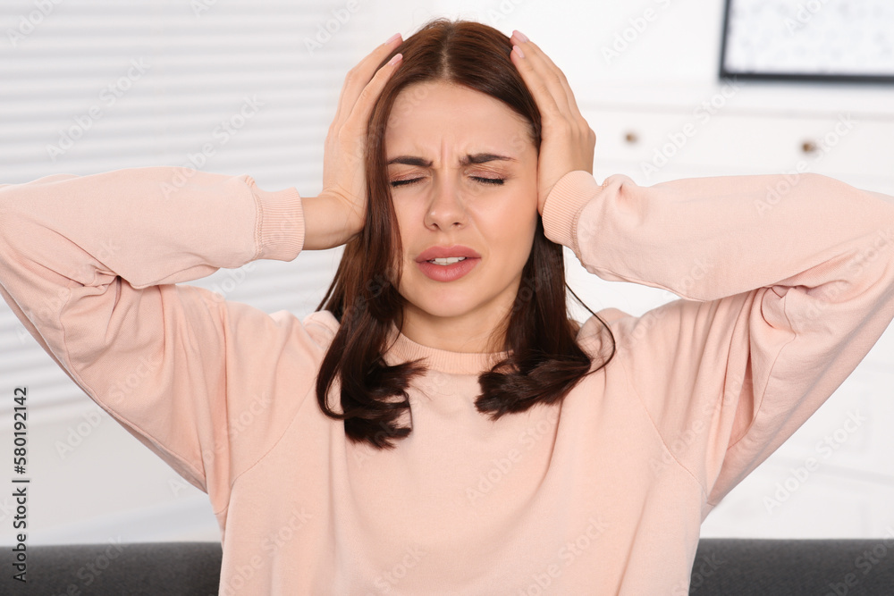Young woman suffering from headache indoors. Hormonal disorders Young woman suffering from headache indoors. Hormonal disorders