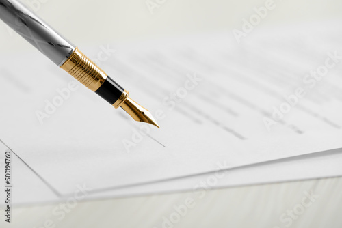 Signing document with fountain pen, closeup. Notary services