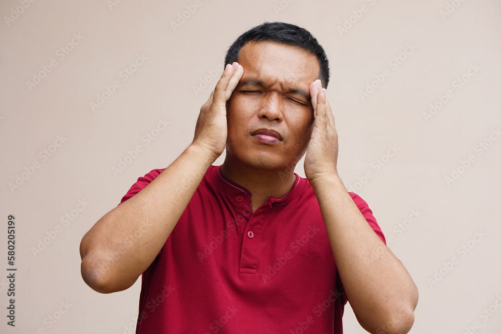 Asian man has a headache stress from work. Asian man has a headache stress from work.