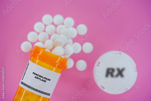 Pancrelipase Amylase Rx medicine pills in plactic vial with tablets. Pills spilling   from yellow container on pink background. photo