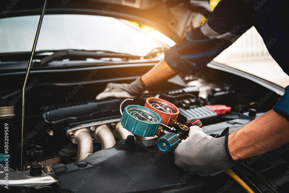 Car care maintenance and service, Hand technician auto mechanic using measuring manifold gauge check refrigerant and filling car air conditioner to fix repairing heat conditioning system. - obrazy, fototapety, plakaty 
