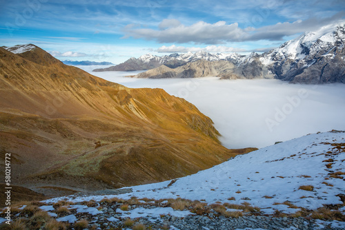 Stelvio pass, mountain dramatic landscape at dawn above mist, Italy