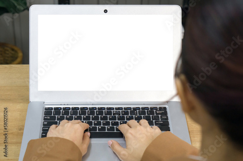 Back view of businesswoman in brown suit sit at desk in office typing on laptop computer keyboard with white screen.