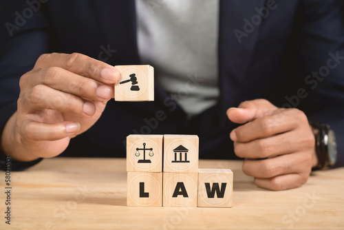 Man holding wooden cube with law icon. Law business and justice banner, scale and fairness. copy space