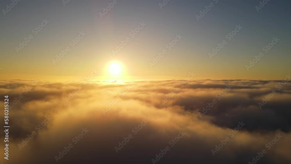 Aerial shot of the sunrise above a layer of clouds