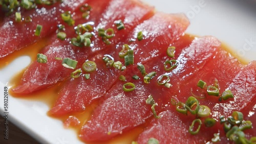 Close-up of delicious appetizer of fresh tuna fish with truffle sauce on a plate. 