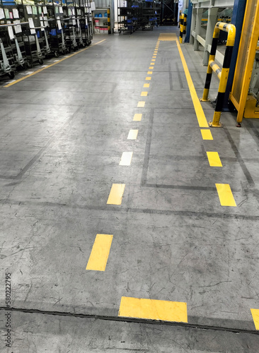 Industrial building corridor painted yellow between parallel yellow lines on abstract cement background. Sidewalk Negotiation Safety Concept