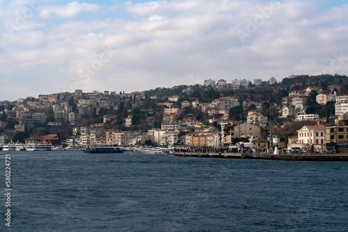 View of the Arnavutkey district of Istanbul on the European part of the city behind the Bosphorus Bridge from the water area of the Bosphorus on a sunny day, Istanbul, Turkey © Ula Ulachka