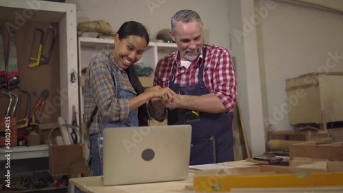 4K Carpenter couples are talking to customers online or over the phone. They're presenting about woodworking and delighted after closing the big lot sale at Wood Factory in wood craftsmanship concept.