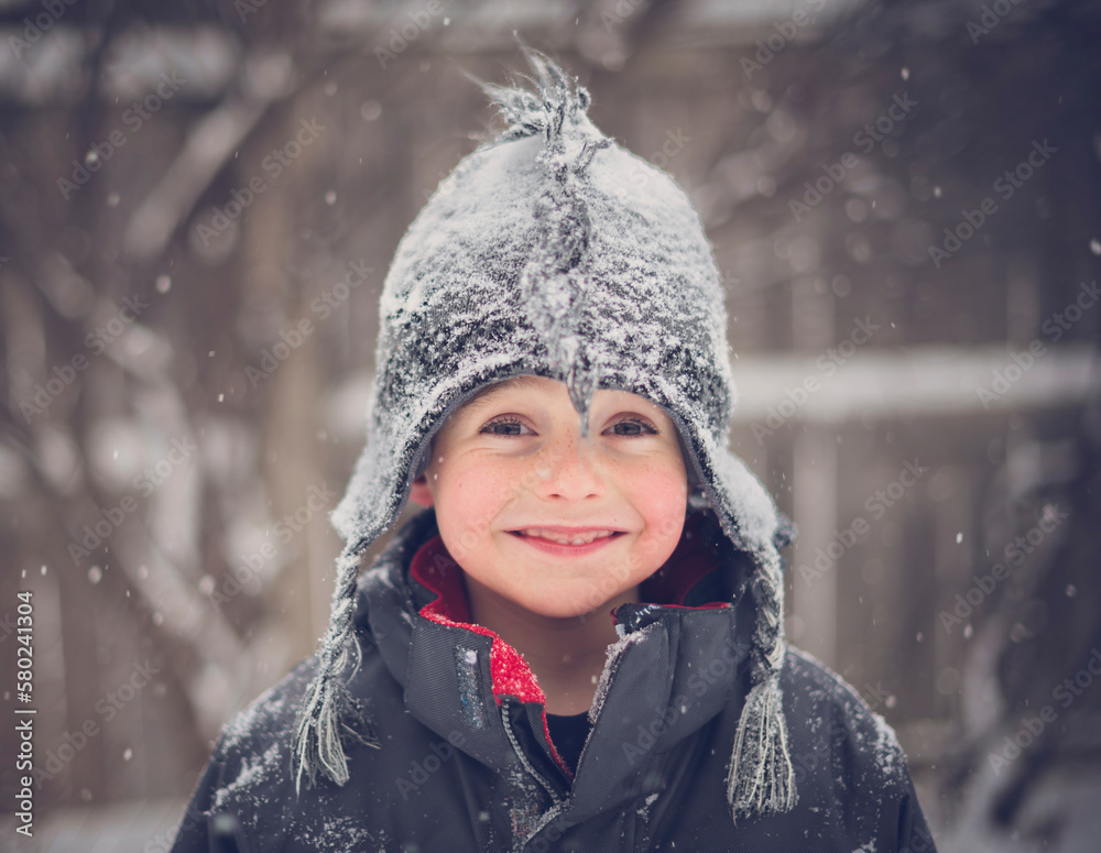 Portrait of cheerful boy wearing hat during snowfall Portrait of cheerful boy wearing hat during snowfall