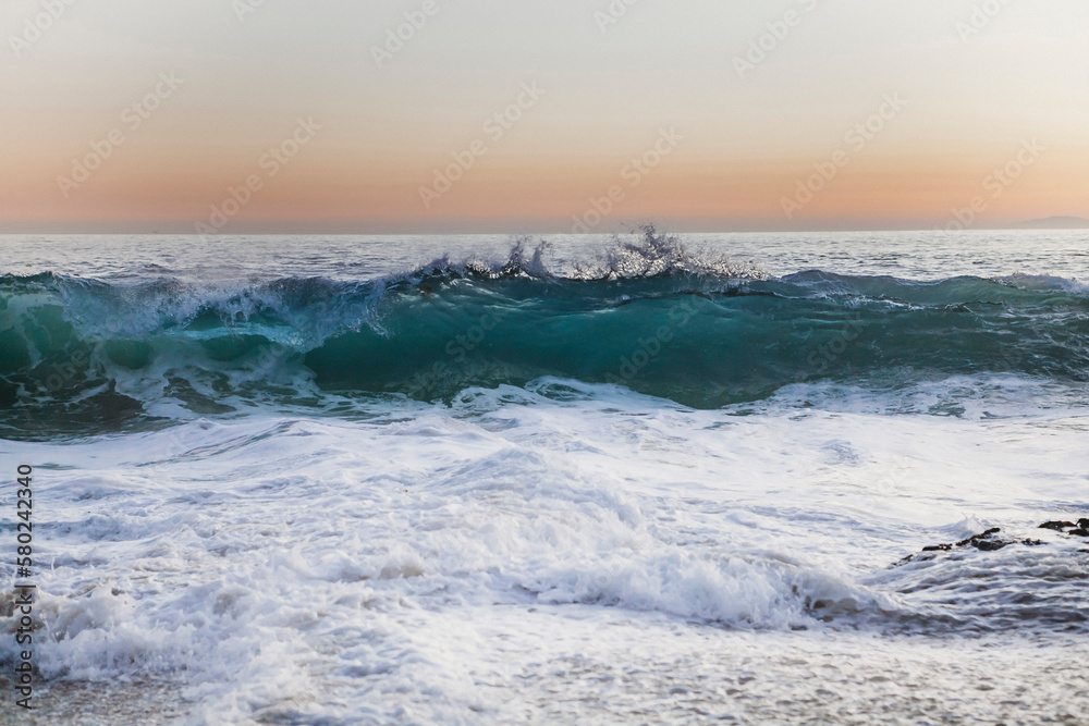 Idyllic view of waves in sea against sky during sunset Idyllic view of waves in sea against sky during sunset