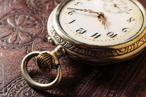 Vintage classic antique clock on leather book background