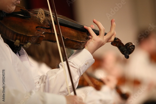 Photo Person playing the violin with a bow wooden stringed musical instrument in hand