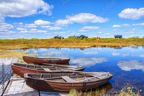 Εκτύπωση καμβά Idyllic landscape view with row boats at a mountain huts jetty