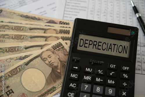 Yen money depreciation concept. depreciation word on calculator with yen money and monetary policy Yen depreciates report. photo