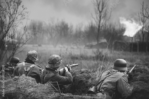 Foto Re-enactors Armed Rifles And Dressed As World War Ii German Wehrmacht Infantry Soldiers Fighting Defensively In Trench