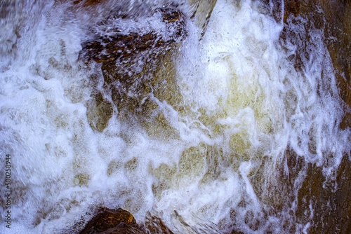 A mountain river flows between rocks in a cascade, Cindrel mountains, Sibiu, Romania photo