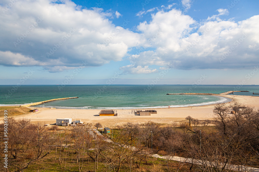 View of the empty beach and the sea, in early spring with bare trees in the city of Constanta Romania.