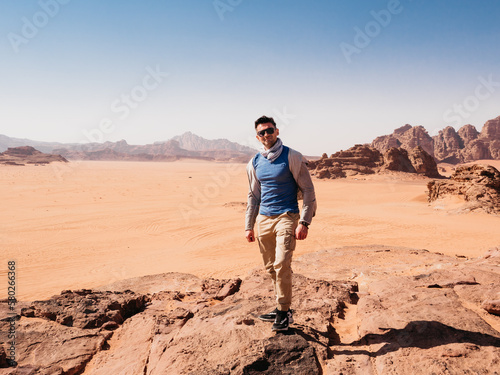 Stylish man and the sights of the Wadi Rum desert in Jordan. Clear  sunny day. Vacation and travel concept