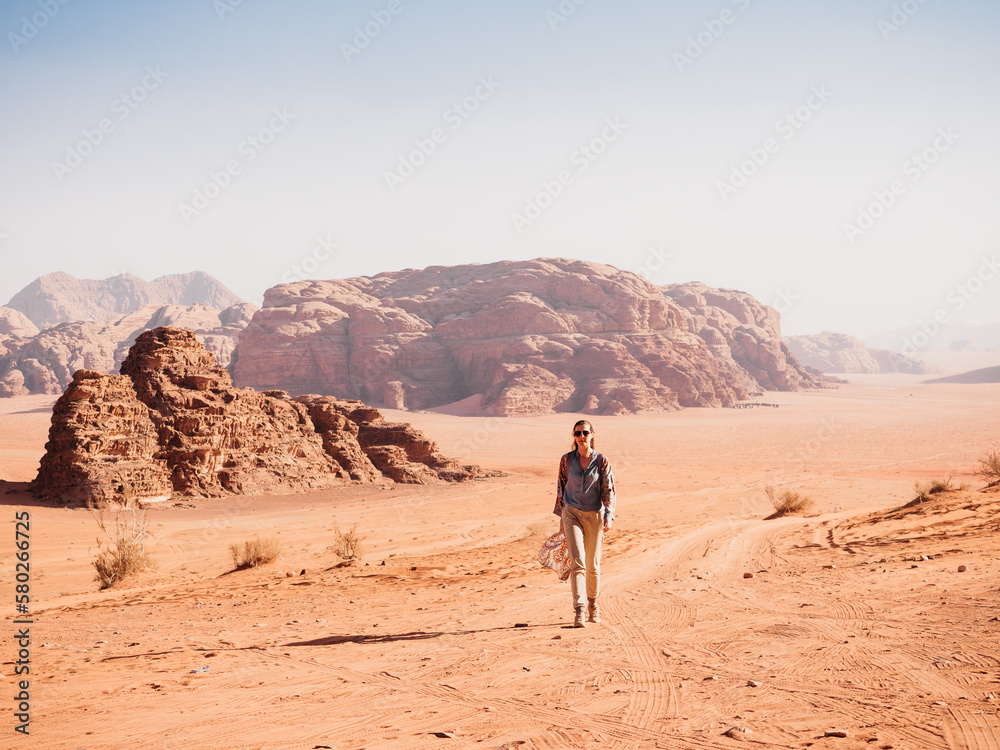 Stylish woman and the sights of the Wadi Rum desert in Jordan. Clear, sunny day. Vacation and travel concept Stylish woman and the sights of the Wadi Rum desert in Jordan. Clear, sunny day. Vacation and travel concept