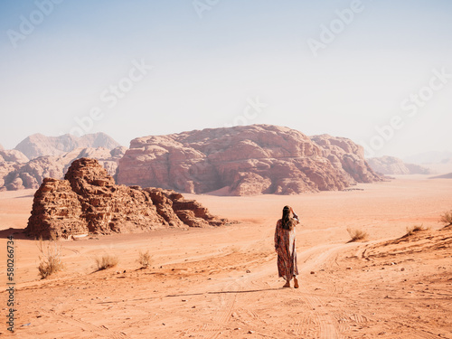 Stylish woman and the sights of the Wadi Rum desert in Jordan. Clear, sunny day. Vacation and travel concept