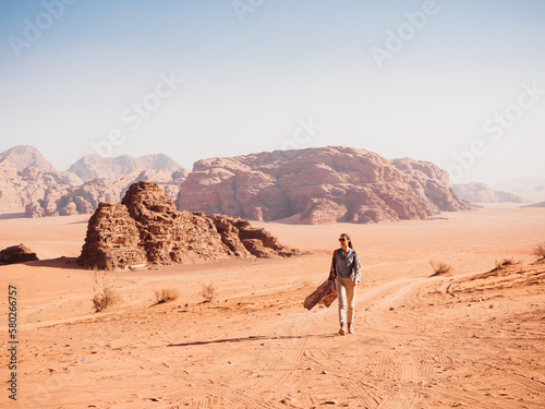 Stylish woman and the sights of the Wadi Rum desert in Jordan. Clear  sunny day. Vacation and travel concept