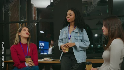 The young businesswoman animatedly discussed her project with her team in the meeting room, her face beaming with positivity and excitement.