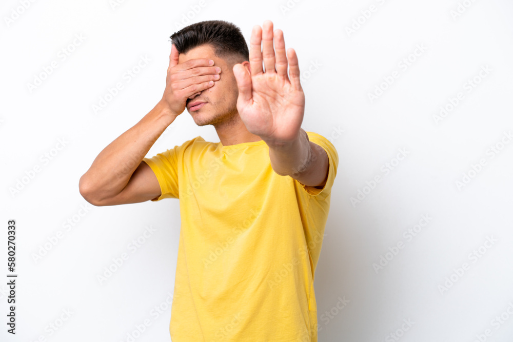 Young caucasian man isolated on white background making stop gesture and covering face