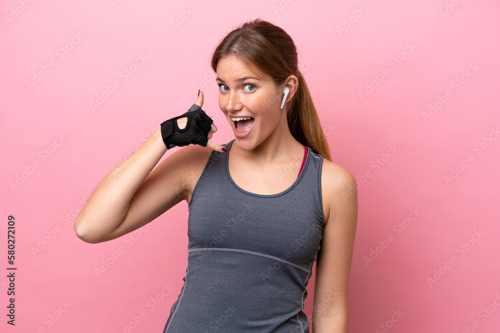 Young sport caucasian woman isolated on pink background making phone gesture. Call me back sign Young sport caucasian woman isolated on pink background making phone gesture. Call me back sign