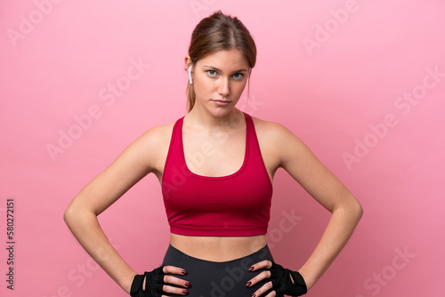 Young caucasian woman isolated on pink background posing with arms at hip