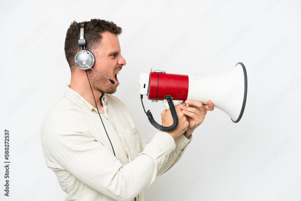 Telemarketer caucasian man working with a headset isolated on white background shouting through a megaphone Telemarketer caucasian man working with a headset isolated on white background shouting through a megaphone