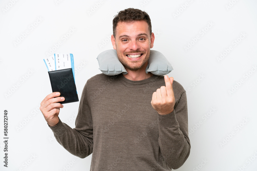 Young caucasian man holding a passport isolated on white background making money gesture Young caucasian man holding a passport isolated on white background making money gesture
