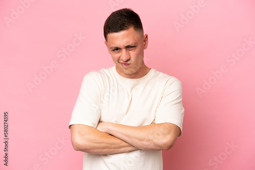 Young Brazilian man isolated on pink background with unhappy expression