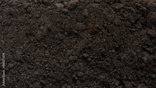 Textured brown earth surface as a background. Fertile soil. View from above. Organic composition of the soil.