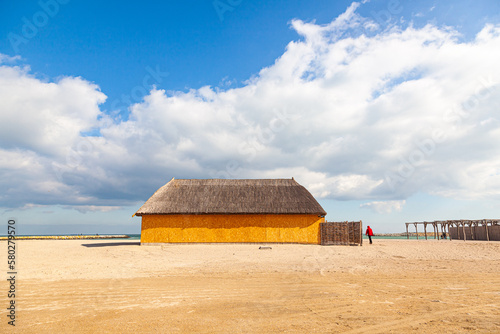 фотографія Empty beach with a thatched roof hut and the sea in early spring on a sunny day