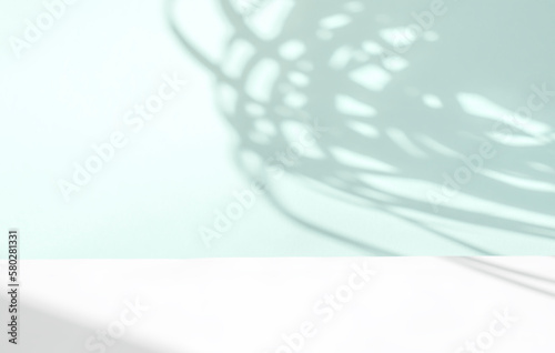 Abstract light turquoise background. The shadow of tropical plant leaves on a paper wall.
