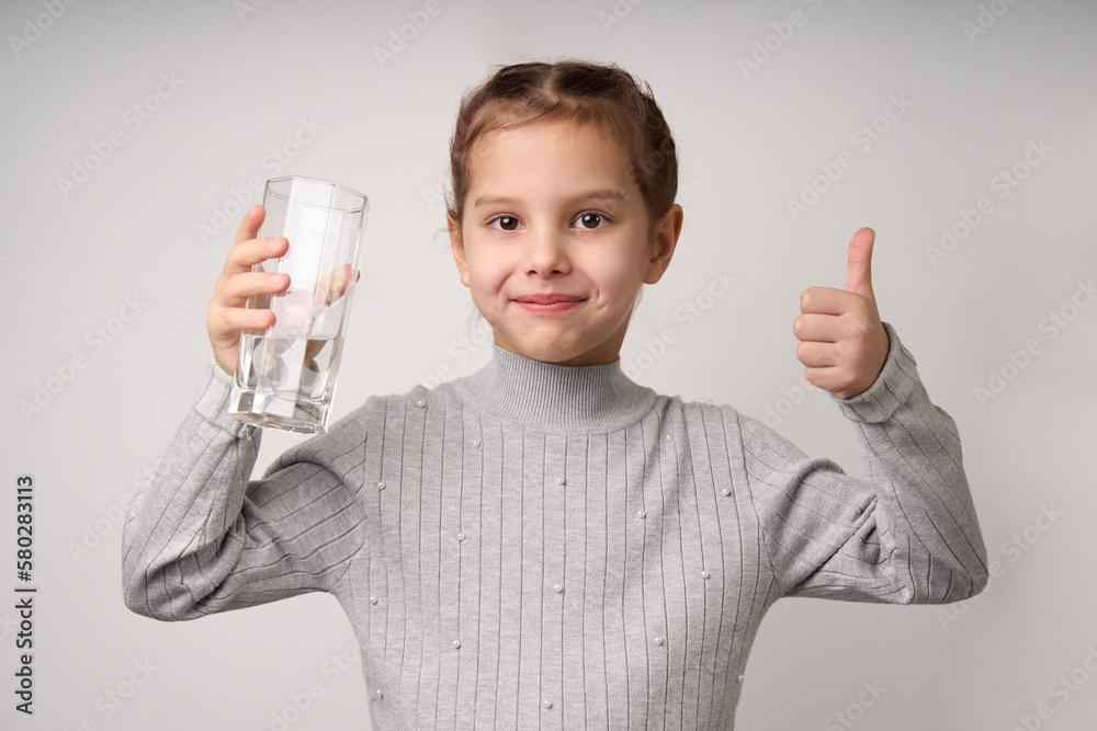 Cute little girl drinking water from glass, close-up Cute little girl drinking water from glass, close-up