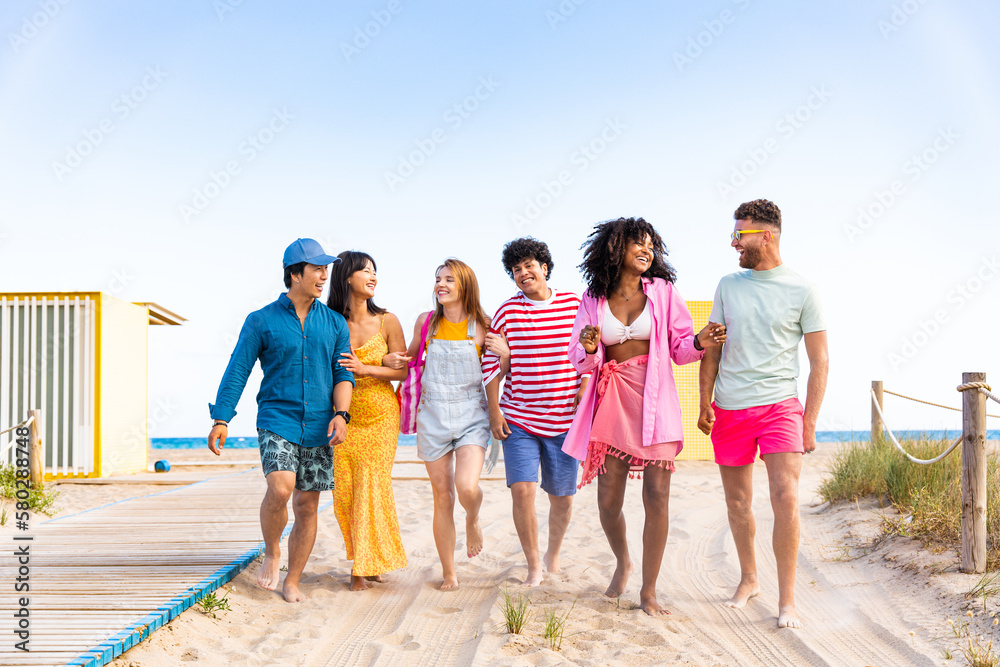 Multiethnic group of happy friends bonding and having fun at the beach on summer vacation - Multiracial real authentic people spending time together at the sea, concepts about youth and summertime Multiethnic group of happy friends bonding and having fun at the beach on summer vacation - Multiracial real authentic people spending time together at the sea, concepts about youth and summertime