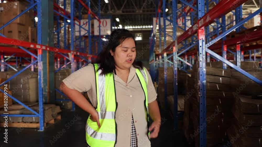 Asian Obese woman having heart attack and lying dawn on the floor at warehouse factory. Wholesale Merchandise. shelves, pallets and boxes