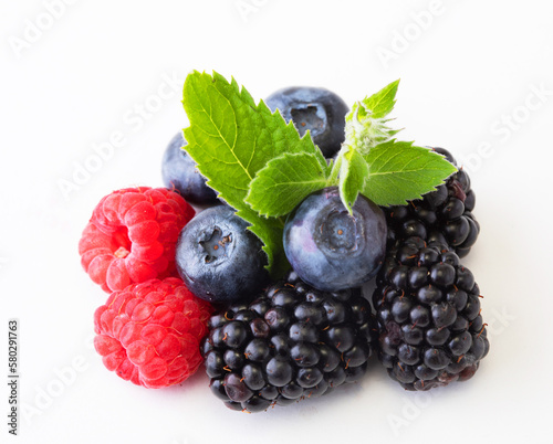 Various berries isolated on white background. Raspberry, Blueberry, Cranberry, Blackberry and Mint leaves