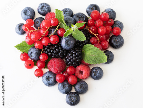 Fototapeta Naklejka Na Ścianę i Meble -  Mix berries with leaf in the shape of a heart. Various fresh berries isolated on white background.