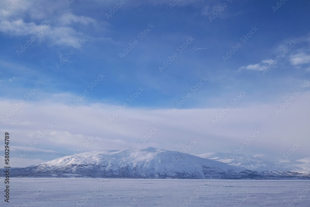 Beautiful scenery of snowy mountains in clouds. View from Lake Torneträsk (Tornestrask) around Abisko National Park (Abisko nationalpark). Sweden, Arctic Circle, Swedish Lapland