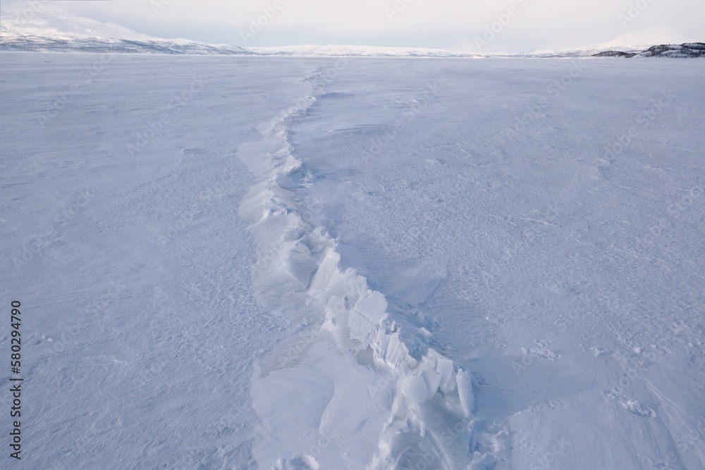 Obraz premium Close up of trace of broken ice sheet on frozen lake. Lake Torneträsk (Tornestrask) around Abisko National Park. Sweden, Arctic Circle, Swedish Lapland