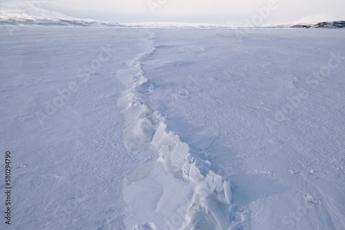 Close up of trace of broken ice sheet on frozen lake. Lake Torneträsk (Tornestrask) around Abisko National Park. Sweden, Arctic Circle, Swedish Lapland