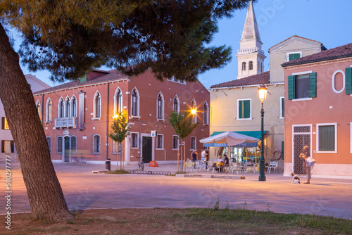 Malamocco. Venezia. Piazza con Palazzo Pretorio e persone al crepuscolo photo