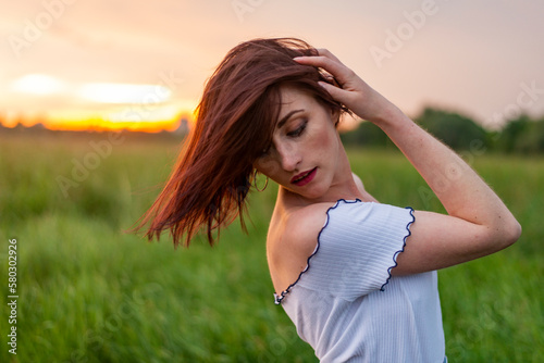 portrait of a beautiful red-haired girl sunset