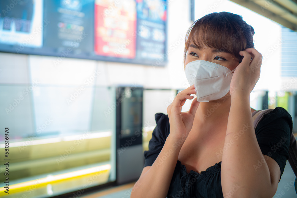 Asian woman wear n95 mask in city train station air pollution